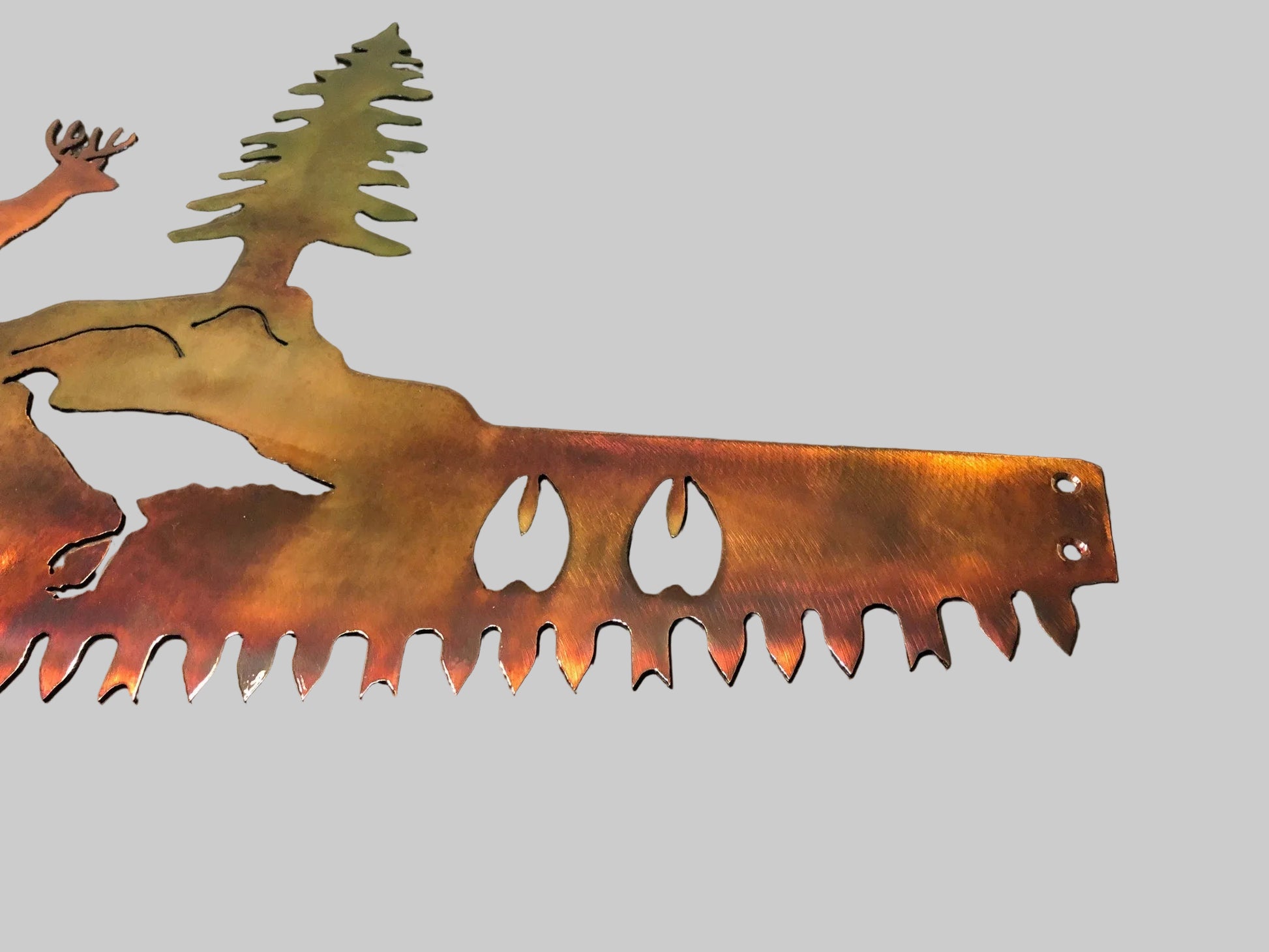 Wildlife crosscut saw metal wall decor featuring a buck, turkey, trees, and animal silhouettes in patina-finished steel.