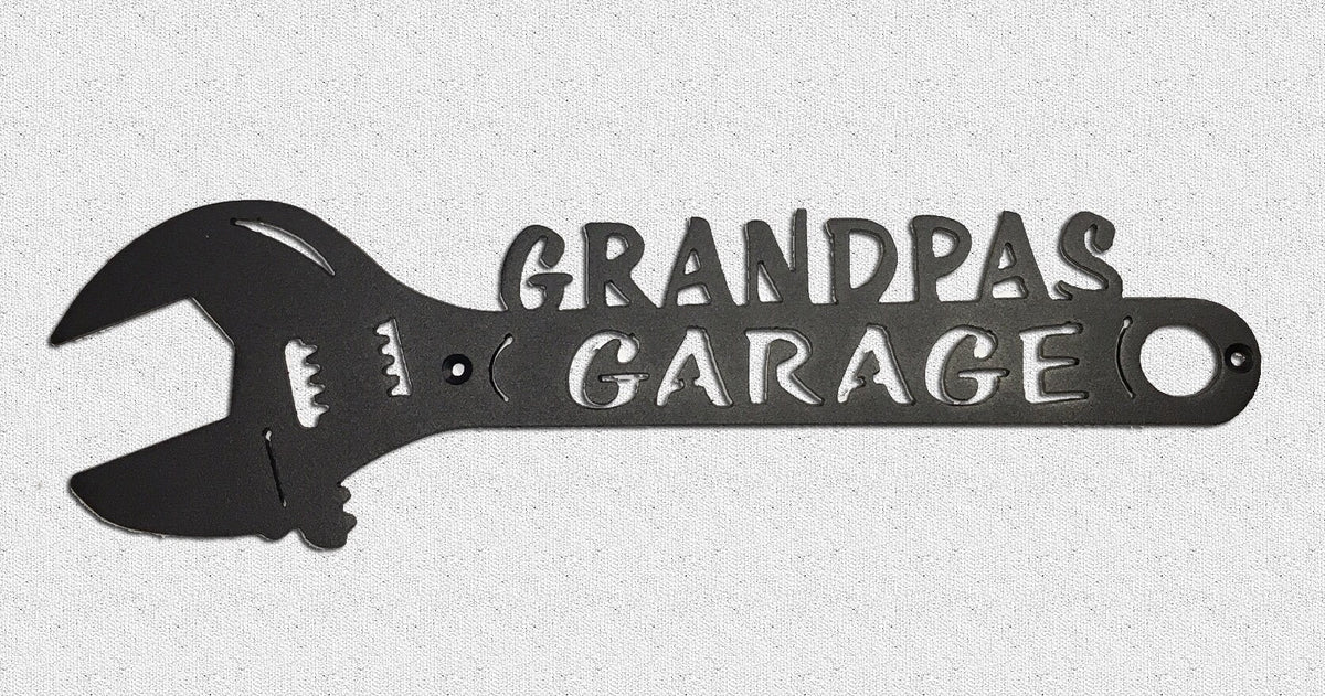 A plasma cut metal art wrench with the text 'GRANDPA'S GARAGE' on it, with a black and gray color scheme.