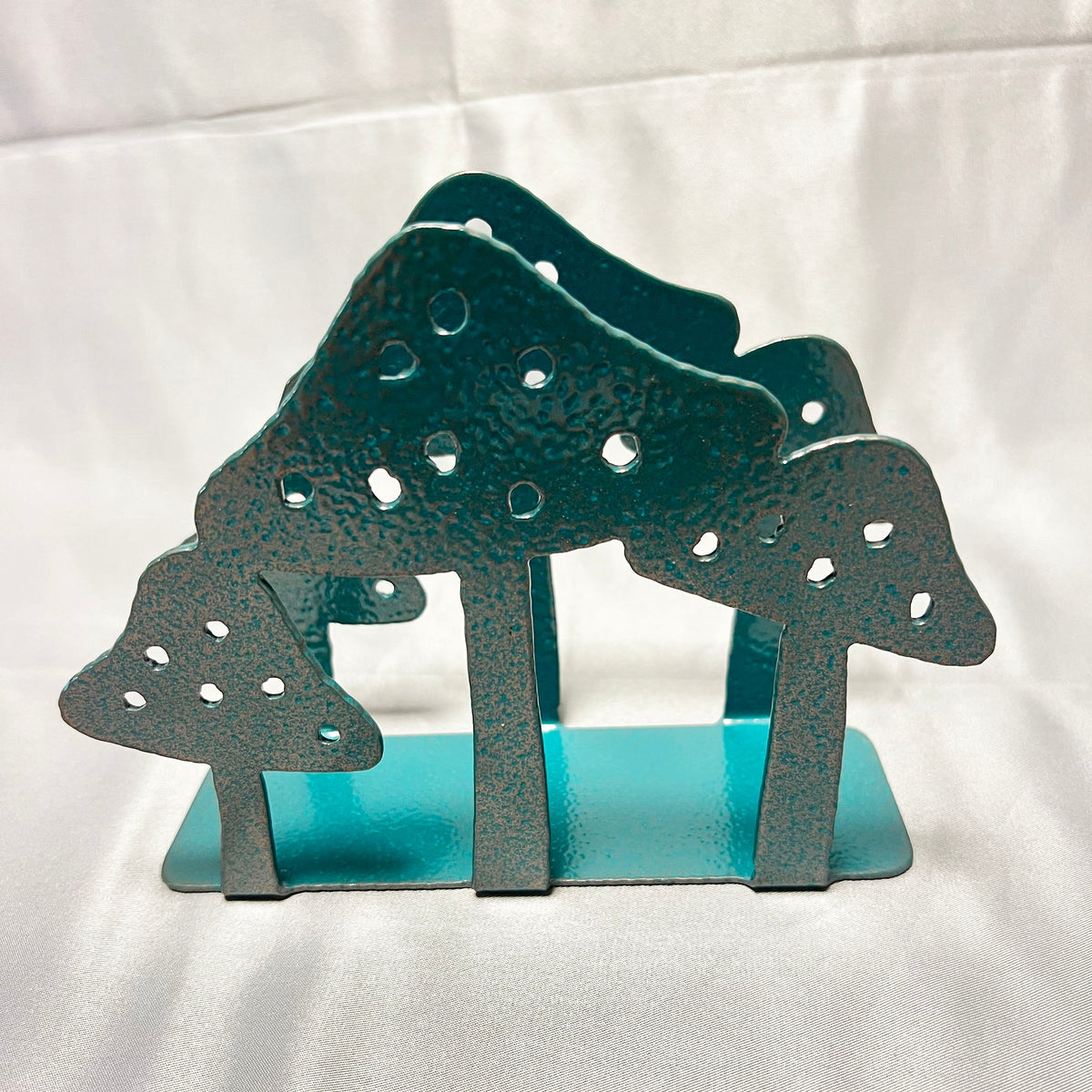 Front view of decorative mushroom napkin holder with turquoise powder coated base