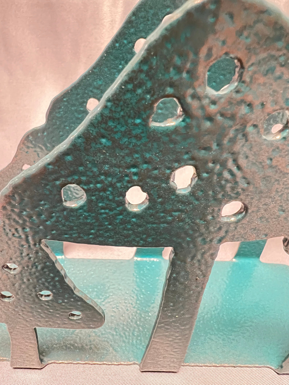 Close-up of textured finish and cutout details on handmade metal mushroom napkin holder