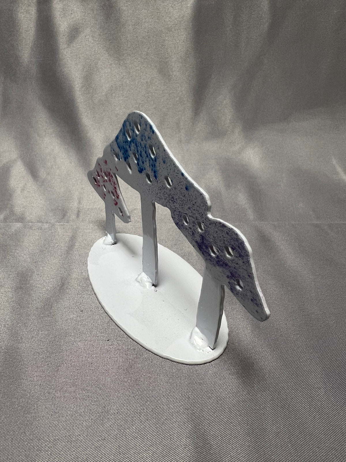 Three-quarter view of handmade mushroom sculpture with white oval base