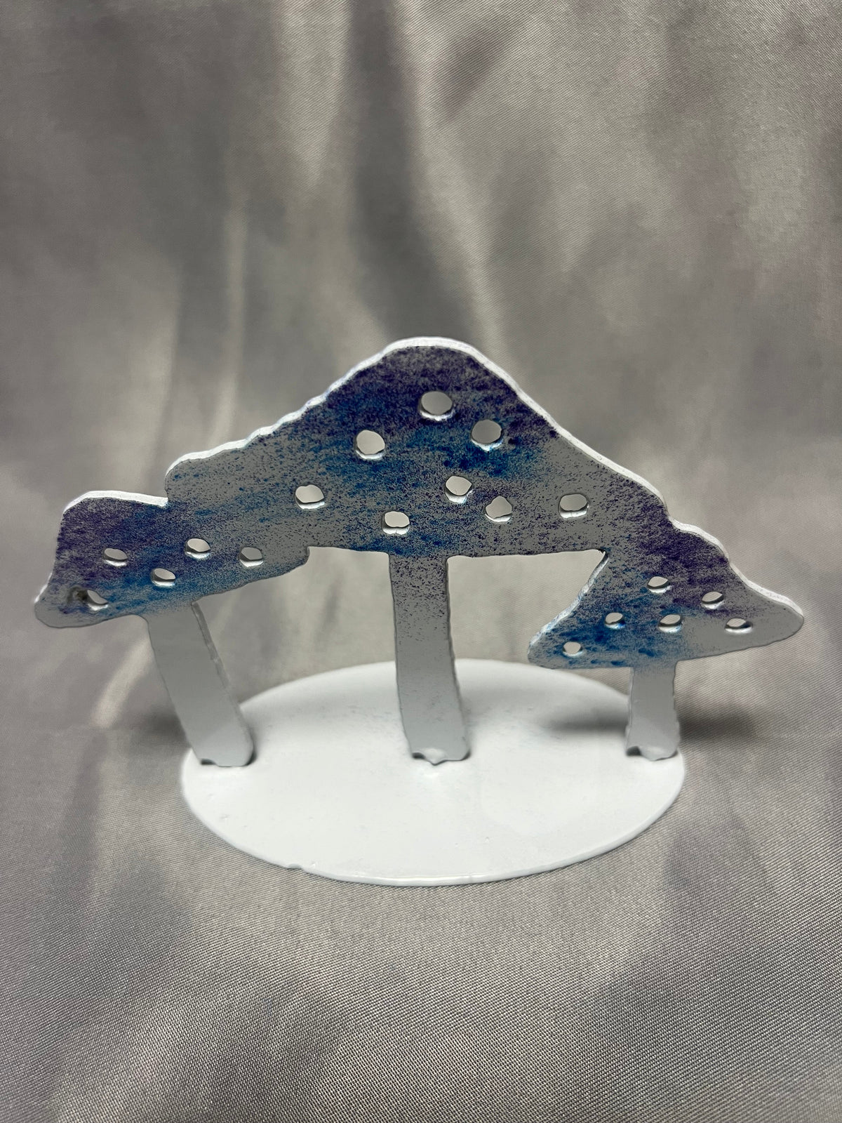 Freestanding metal mushroom sculpture with blue and purple mushroom caps