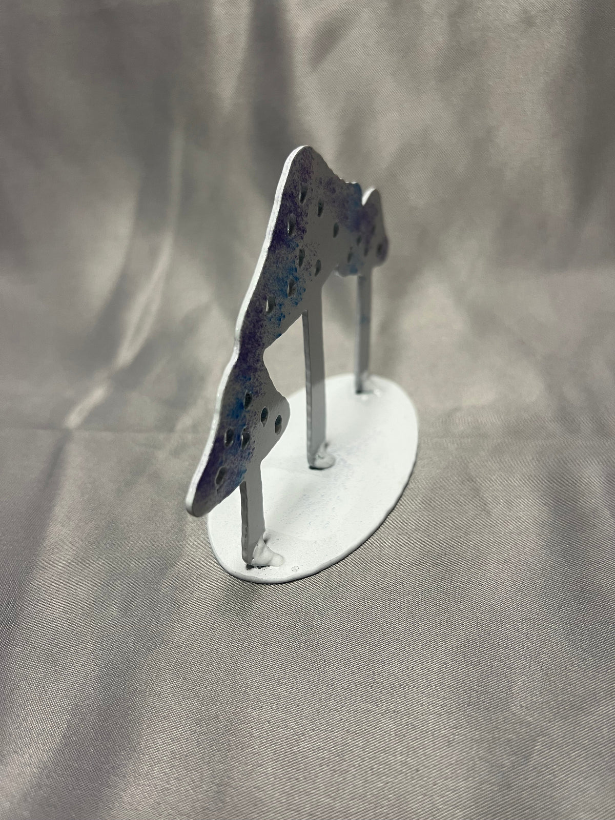 Side view of freestanding metal mushroom figurine showing steel construction