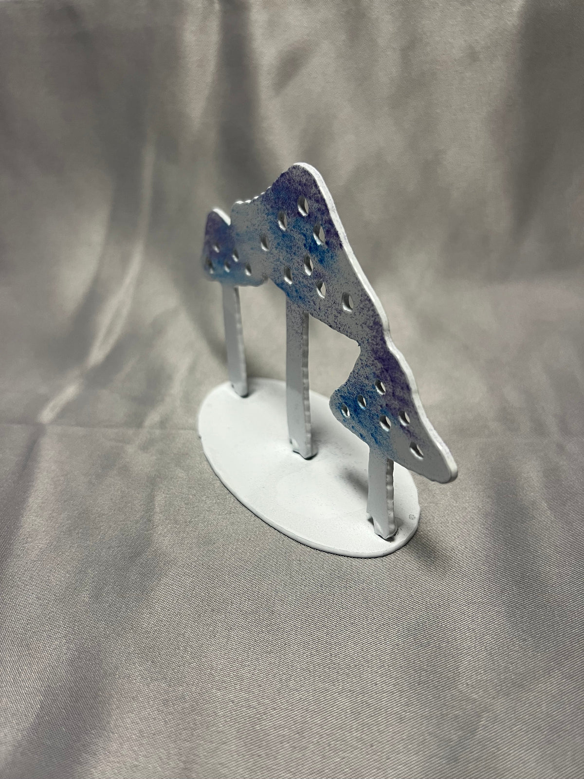 End view of small handmade metal mushroom sculpture for shelf or desk decor