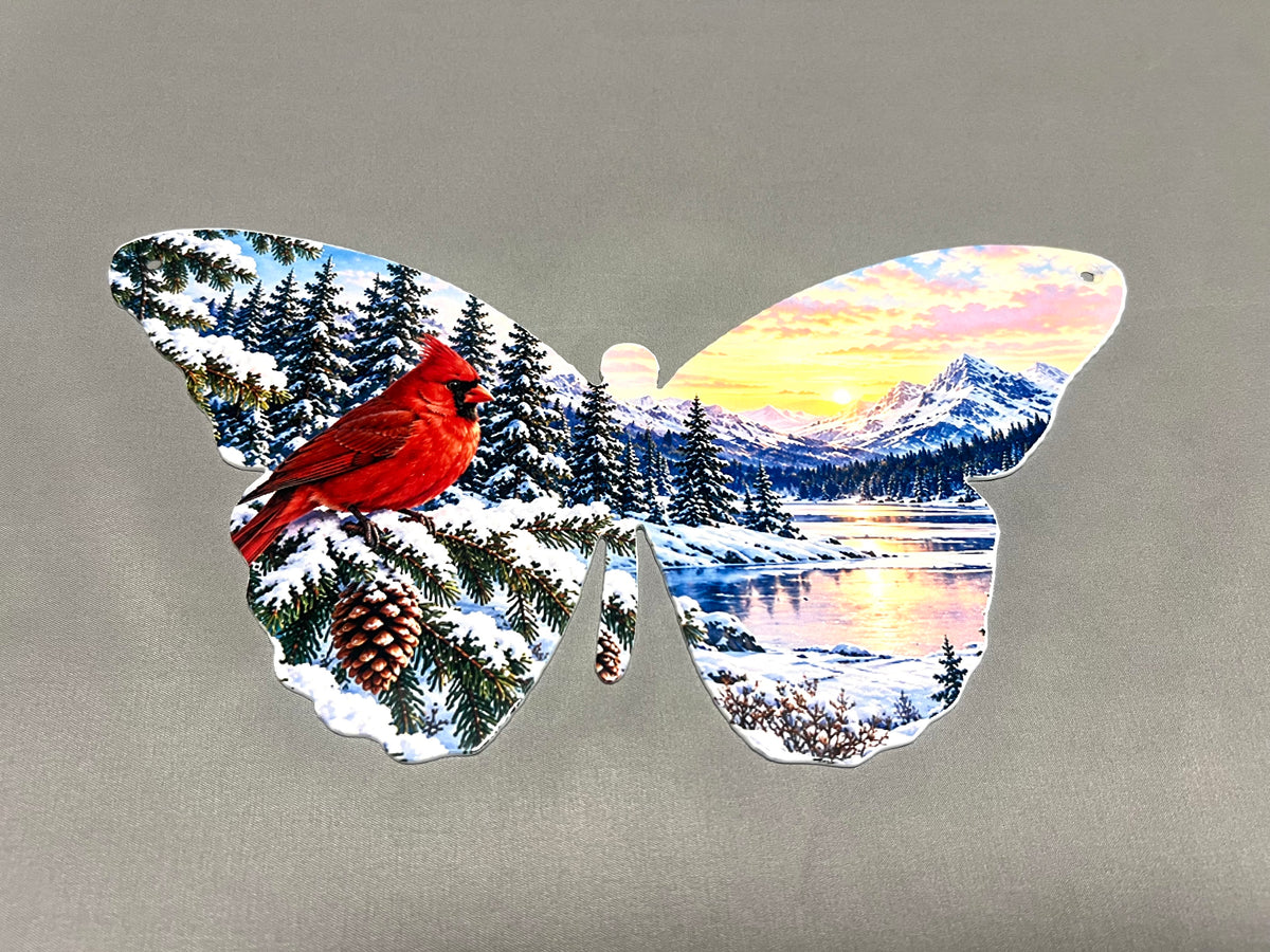Full view of butterfly-shaped metal wall art featuring a red cardinal, snowy evergreen trees, mountains, and a winter lake.