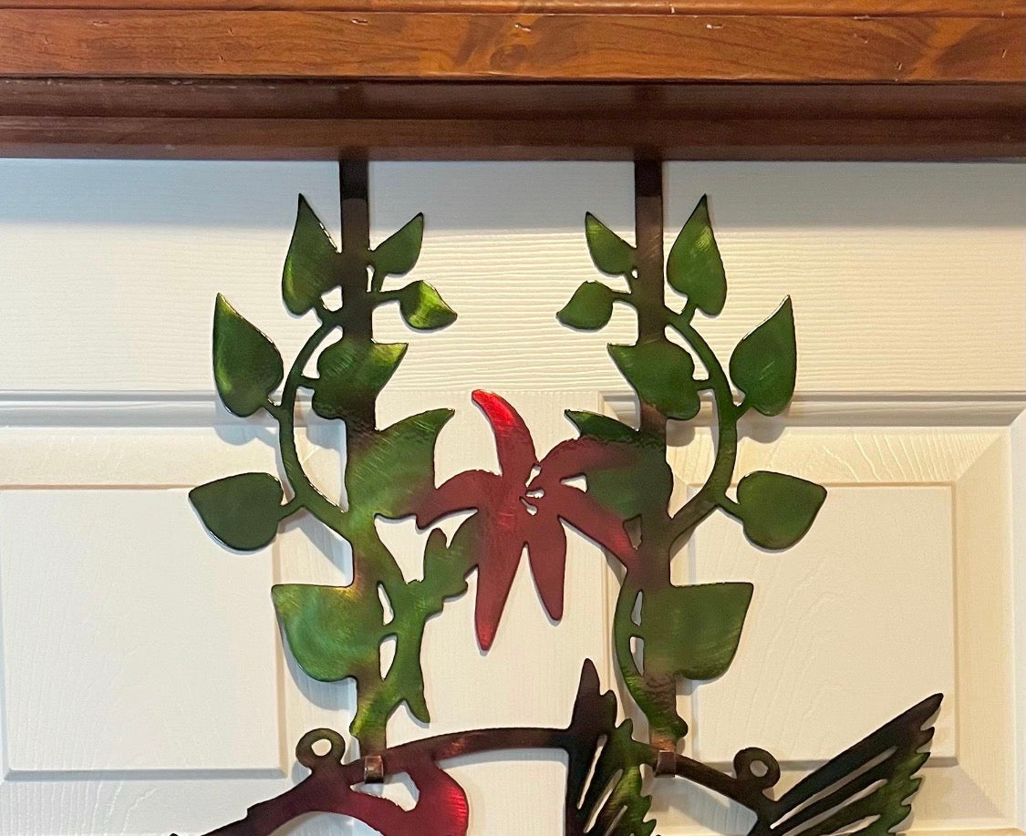 Upper floral section of hummingbird metal door hanger mounted over a white door.