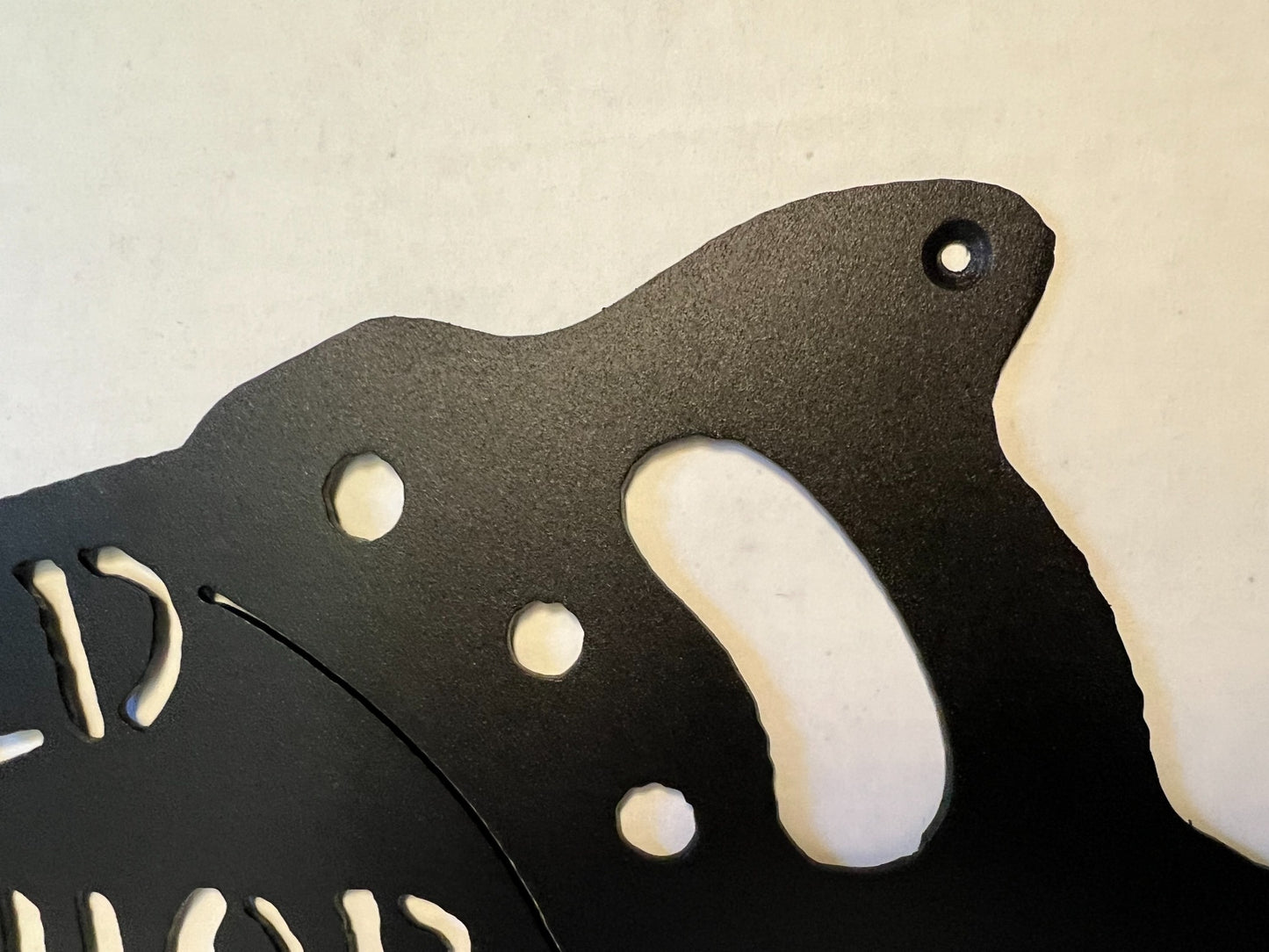 Close-up of handsaw handle details on the metal shop sign