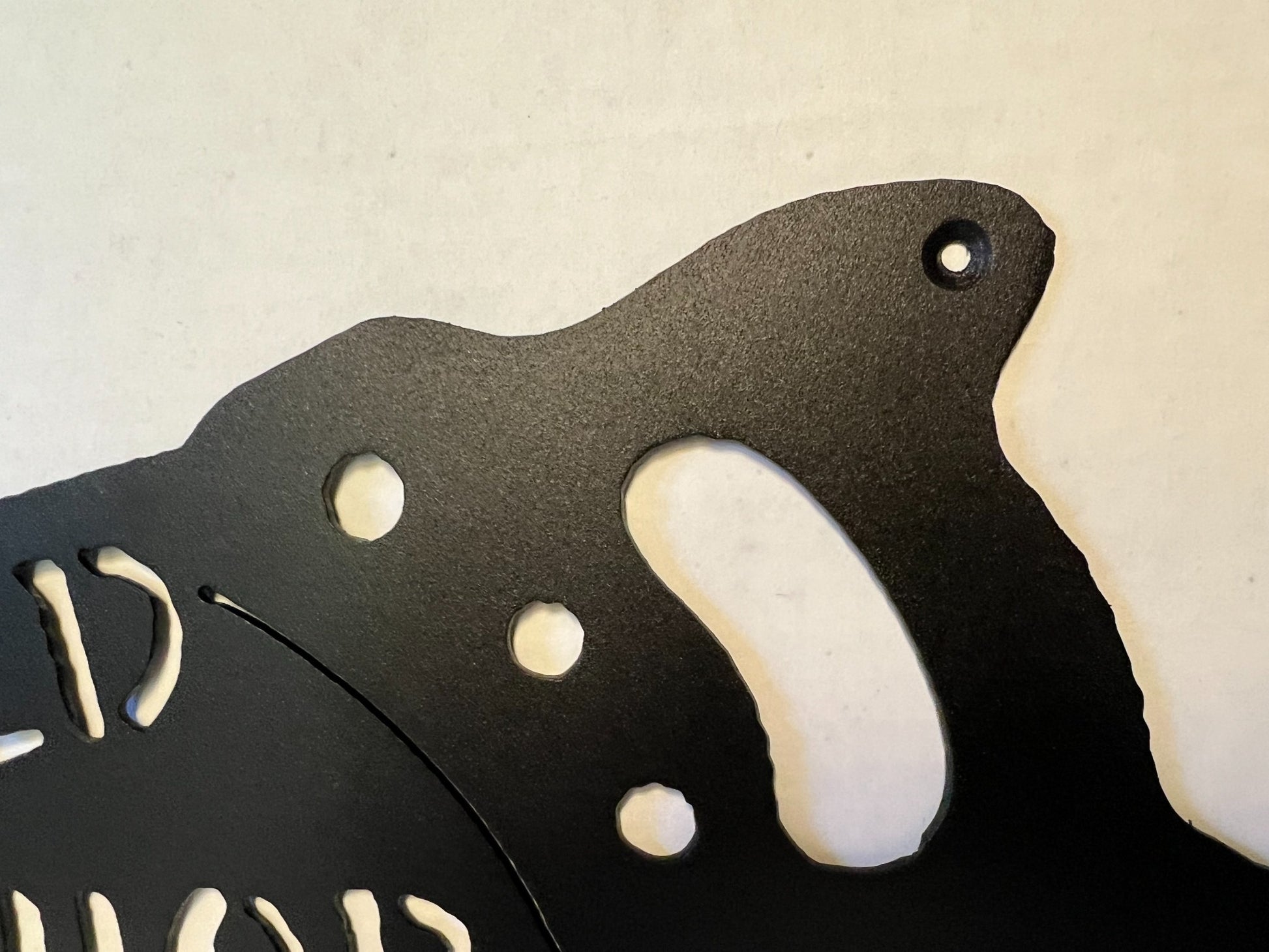 Close-up of handsaw handle details on the metal shop sign