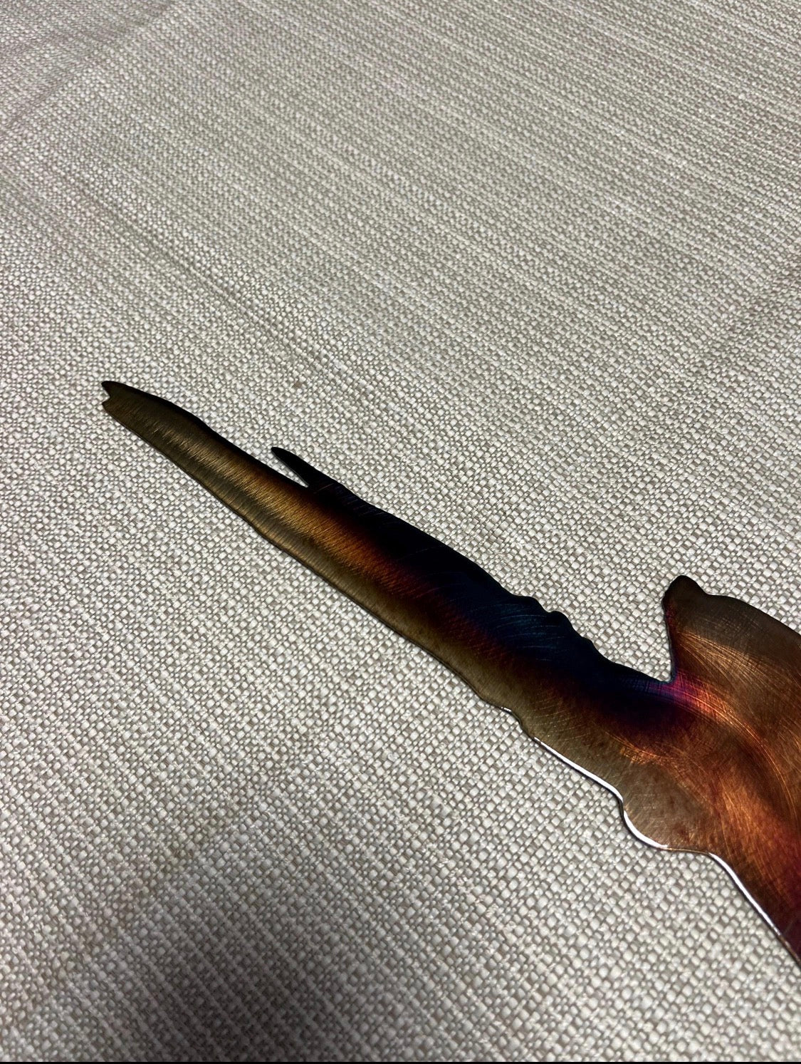 Close-up of the roadrunner tail showing layered silhouette details and multicolor hand-finished steel patina.
