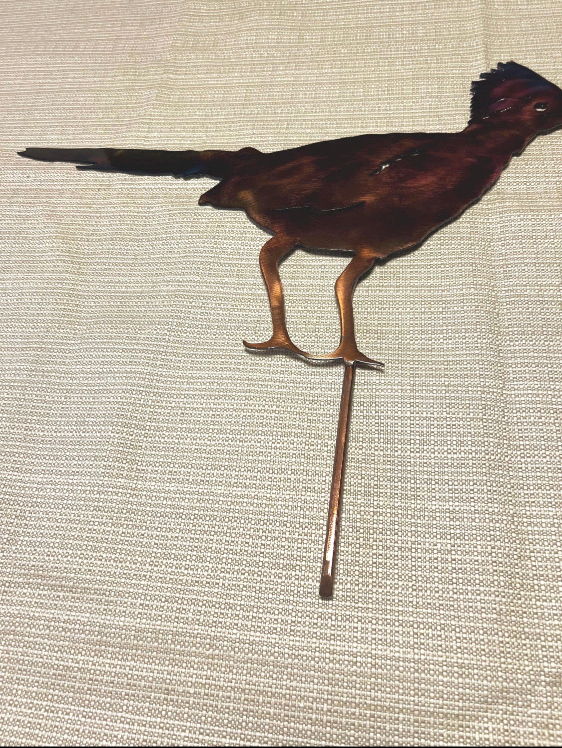 Hand-finished steel roadrunner yard stake shown in full side view with multicolor patina.