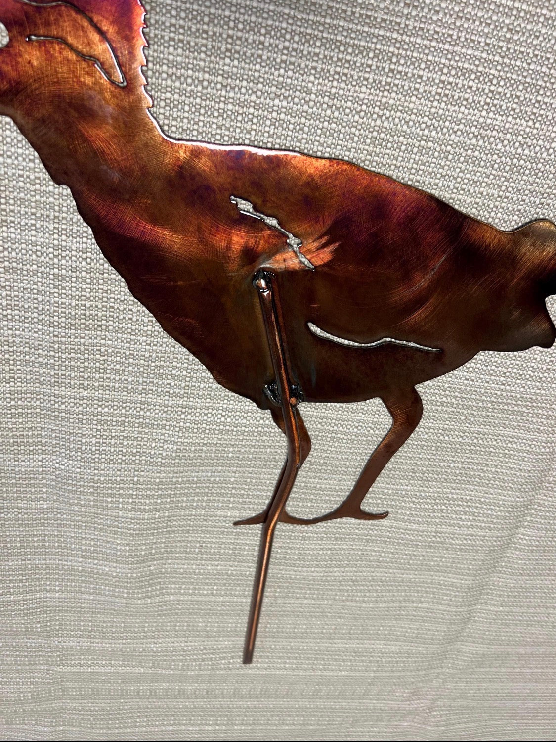 Close-up of the welded steel yard stake attachment on the handcrafted roadrunner garden art.