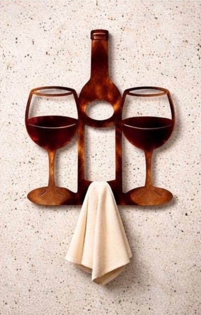 Wine bottle and two wine glasses metal wall art with towel hook displayed on a light concrete wall.