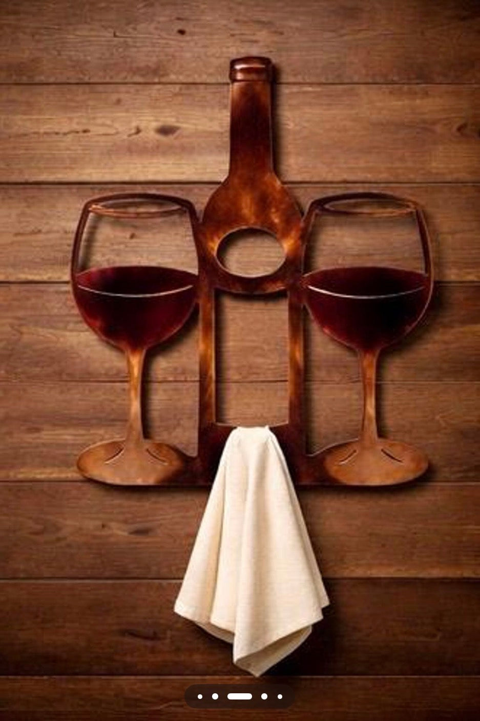 Wine bottle and two wine glasses metal towel hanger displayed on a rustic wood wall.